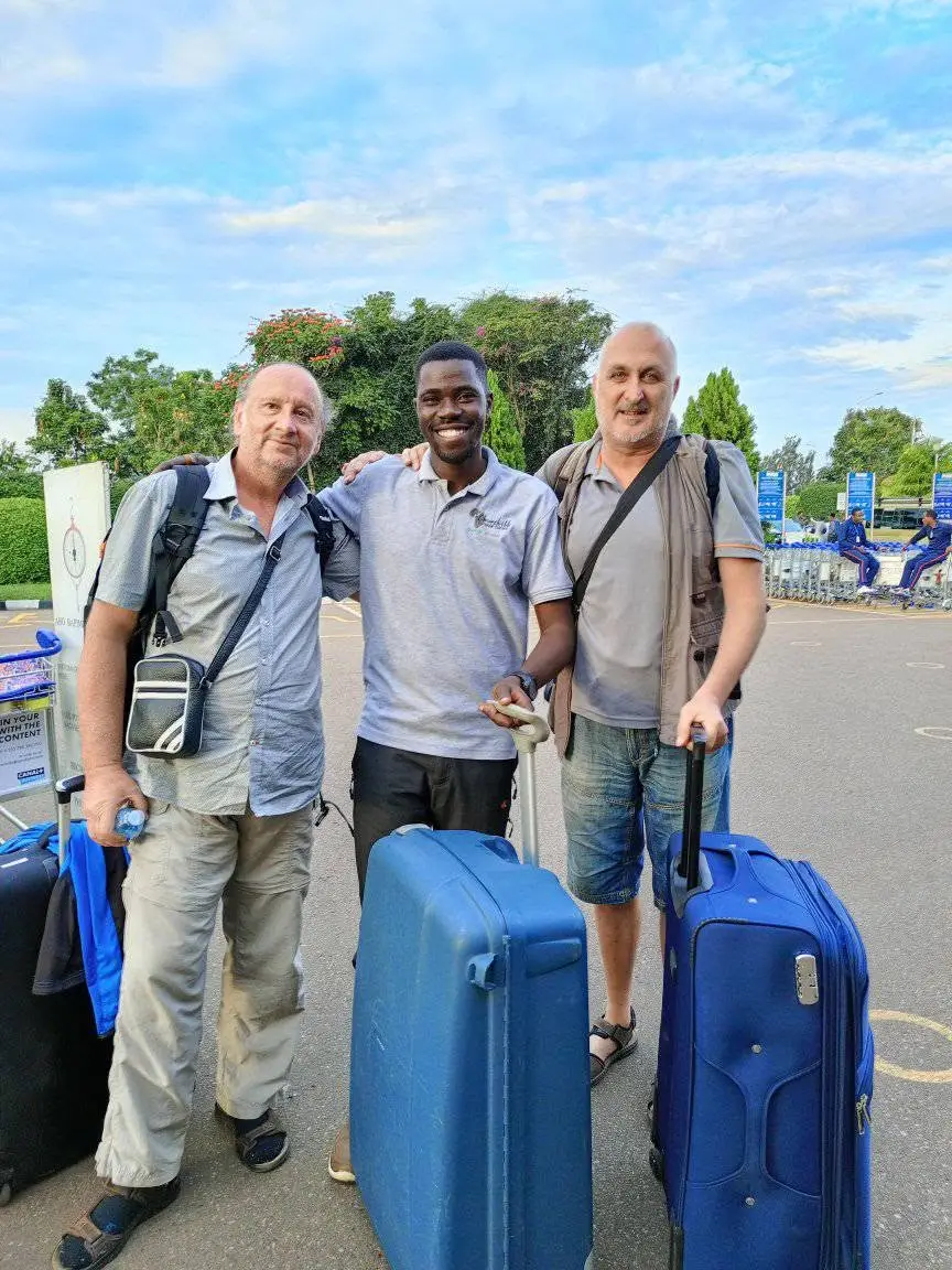 Herbert with two travellers and their suitcases